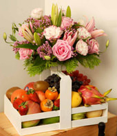 Pink Roses, Pink Lily And Wax Flowers With A Tray Of Assorted Fruits